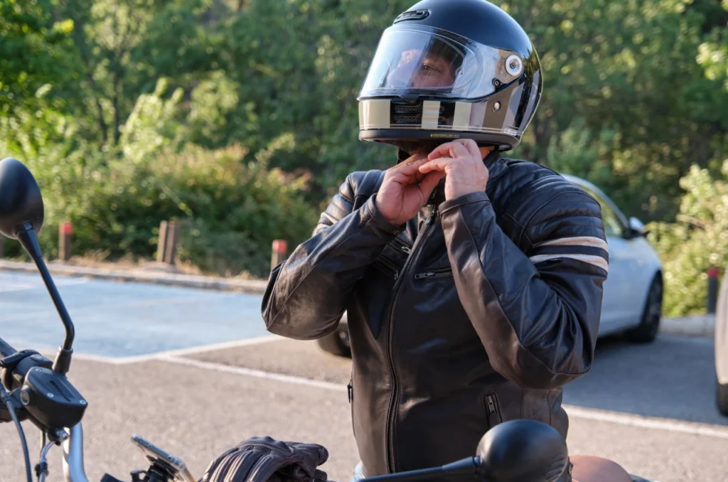Um Motociclista Ajustando O Capacete Antes De Sair Para A Estrada Enfatizando A Importancia De Um Ajuste Adequado Um Motociclista Ajustando O Capacete Antes De Sair Para A Estrada Enfatizando A Importancia De Um Ajuste Adequado